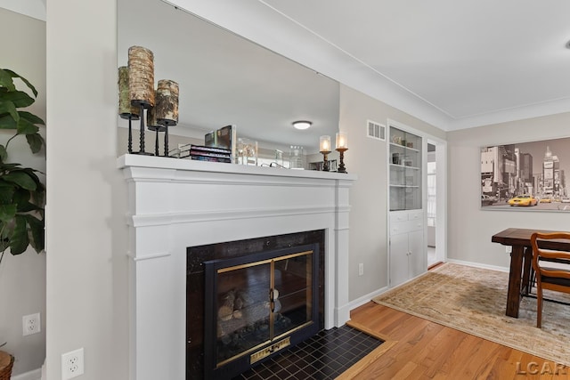 603 Outer Dr, Tecumseh, MI 49286 - living area featuring wood finished floors, a fireplace with flush hearth, and baseboards