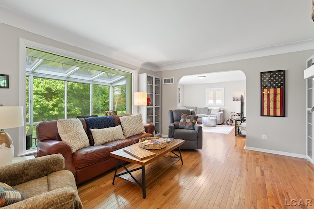 603 Outer Dr, Tecumseh, MI 49286 - living area featuring arched walkways, light wood-type flooring, baseboards, and a sunroom