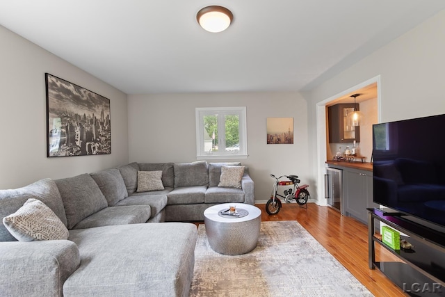 603 Outer Dr, Tecumseh, MI 49286 - living room with light wood-style flooring, bar, wine cooler, and baseboards