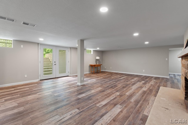 603 Outer Dr, Tecumseh, MI 49286 - below grade area with recessed lighting, a stone fireplace, wood finished floors, and baseboards
