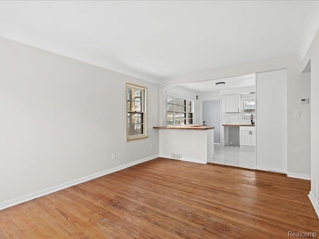 19468 Evergreen Rd, Detroit, MI 48219 - unfurnished living room with light wood finished floors and baseboards