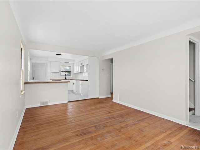 19468 Evergreen Rd, Detroit, MI 48219 - unfurnished living room with light wood-style floors, a sink, and baseboards