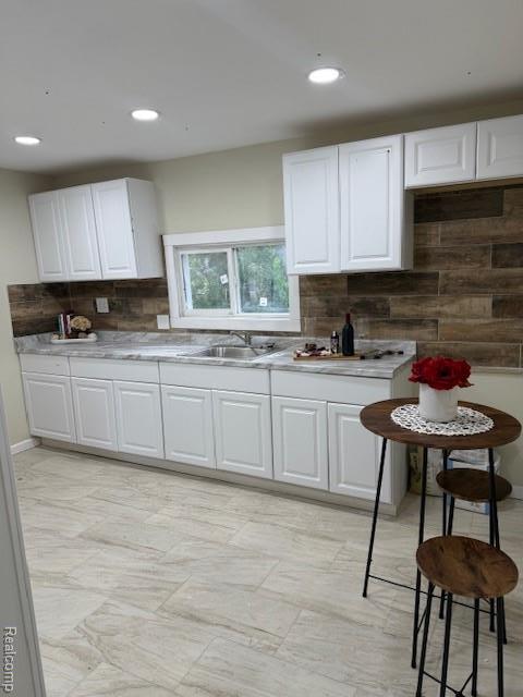 9207 Stout St, Detroit, MI 48228 - kitchen with a sink, tasteful backsplash, white cabinets, light countertops, and recessed lighting