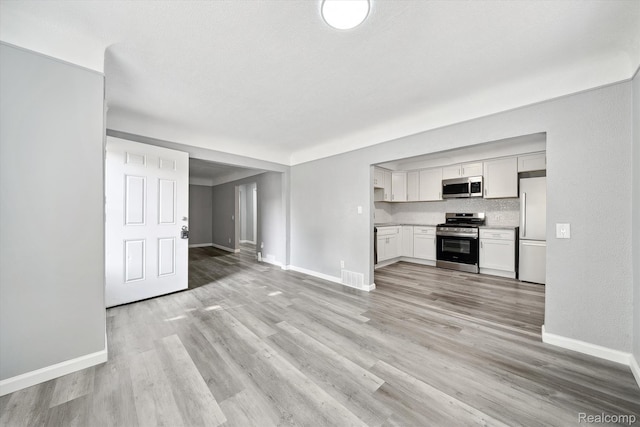 5932 Colorado St, Romulus, MI 48174 - unfurnished living room featuring baseboards and light wood-style floors