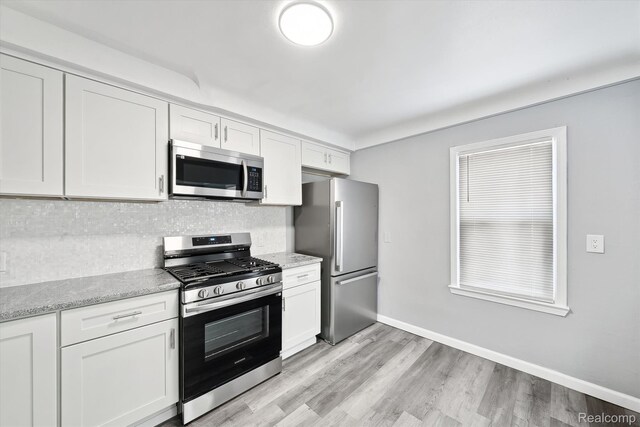 5932 Colorado St, Romulus, MI 48174 - kitchen with stainless steel appliances, decorative backsplash, white cabinetry, and light wood-style flooring