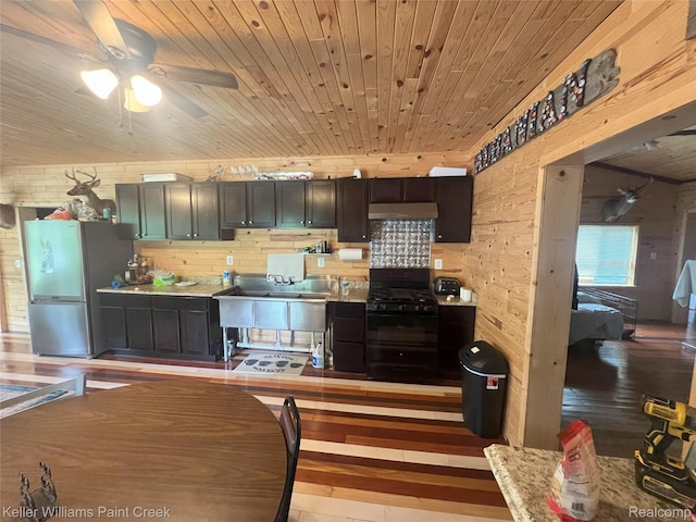 11755 Jakob Ln, Lachine, MI 49753 - kitchen featuring freestanding refrigerator, black gas range oven, wood ceiling, light wood-style floors, and ceiling fan