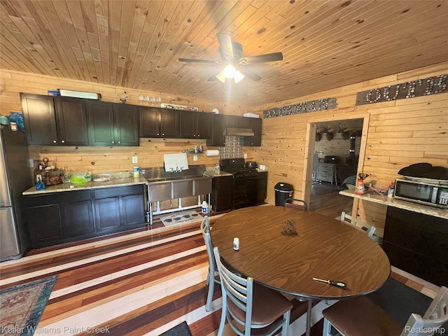 11755 Jakob Ln, Lachine, MI 49753 - dining room with wood walls, a ceiling fan, and wooden ceiling