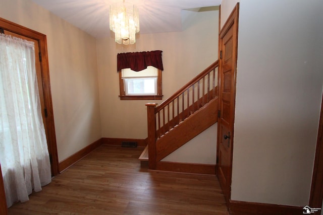 633 Scott St, Monroe, MI 48161 - staircase featuring a chandelier, wood finished floors, and baseboards