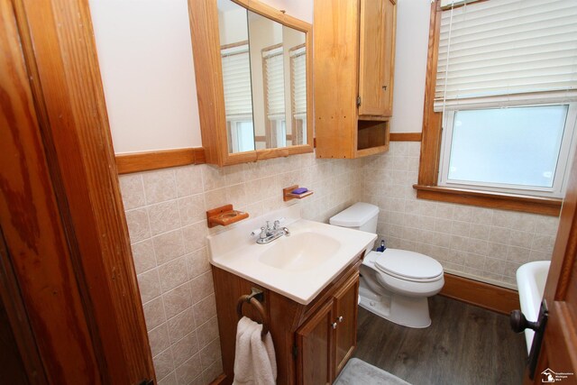 633 Scott St, Monroe, MI 48161 - bathroom with toilet, vanity, wood finished floors, backsplash, and tile walls