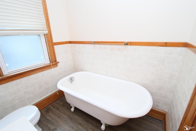 633 Scott St, Monroe, MI 48161 - bathroom featuring tile walls, a soaking tub, wood finished floors, toilet, and wainscoting