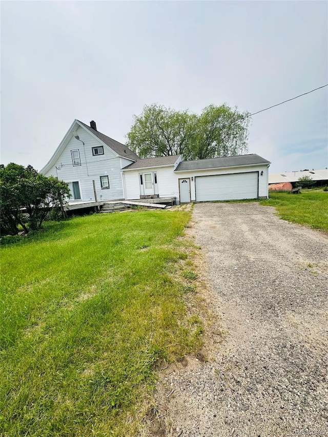 6196 W Plains Rd, Eaton Rapids, MI 48827 - view of front of house with a garage, a front lawn, and gravel driveway