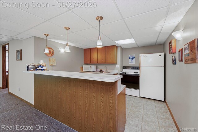 1145 W Moore Rd, Milford, MI 48381 - kitchen featuring white appliances, a drop ceiling, light countertops, a peninsula, and brown cabinets