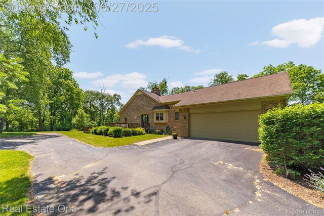 1145 W Moore Rd, Milford, MI 48381 - view of front facade featuring asphalt driveway, brick siding, a garage, and a chimney