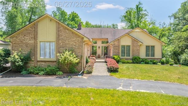 1145 W Moore Rd, Milford, MI 48381 - mid-century home featuring brick siding, a front lawn, and a chimney