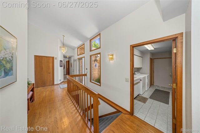1145 W Moore Rd, Milford, MI 48381 - corridor with an upstairs landing, light wood-style floors, washer and dryer, and high vaulted ceiling