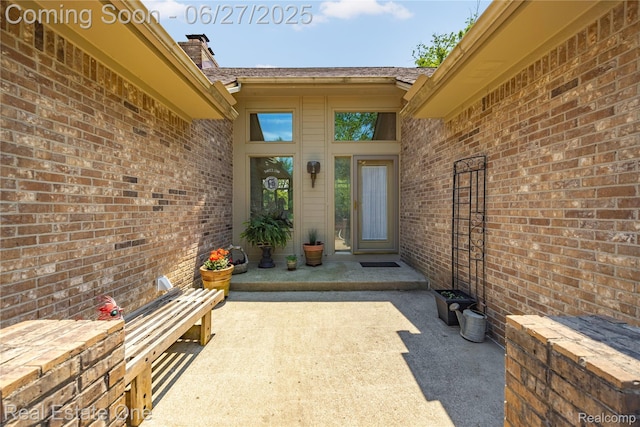 1145 W Moore Rd, Milford, MI 48381 - doorway to property with brick siding, a patio area, and a chimney