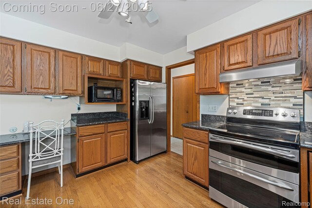 1145 W Moore Rd, Milford, MI 48381 - kitchen featuring stainless steel appliances, under cabinet range hood, and brown cabinetry