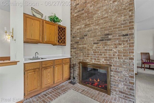 1145 W Moore Rd, Milford, MI 48381 - kitchen featuring light carpet, light countertops, a fireplace, and brown cabinets