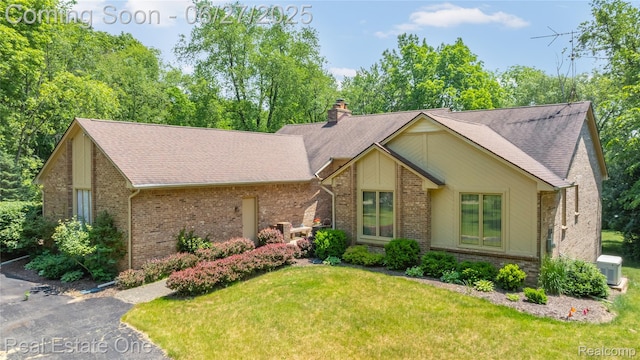 1145 W Moore Rd, Milford, MI 48381 - mid-century modern home with brick siding, a front yard, a chimney, and roof with shingles