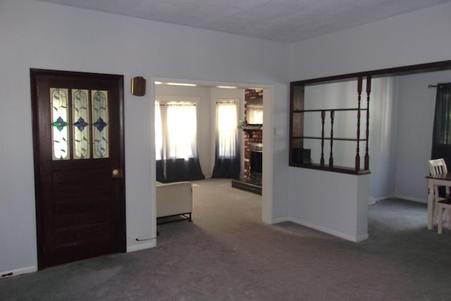 602 Fairview Ave, Manistee, MI 49660 - foyer entrance with carpet floors, a brick fireplace, and baseboards