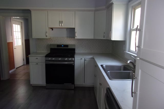 602 Fairview Ave, Manistee, MI 49660 - kitchen featuring stainless steel gas range, freestanding refrigerator, a sink, decorative backsplash, and light countertops