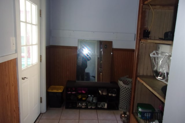 602 Fairview Ave, Manistee, MI 49660 - hallway with wainscoting, tile patterned flooring, and wooden walls