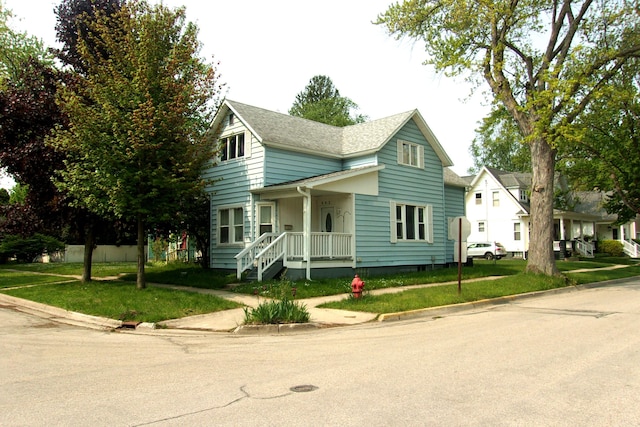 602 Fairview Ave, Manistee, MI 49660 - traditional home featuring a front yard and covered porch