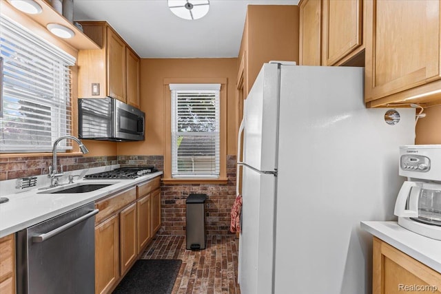 809 E Bennett Ave, Ferndale, MI 48220 - kitchen with stainless steel appliances, a sink, light countertops, and brick patterned floors