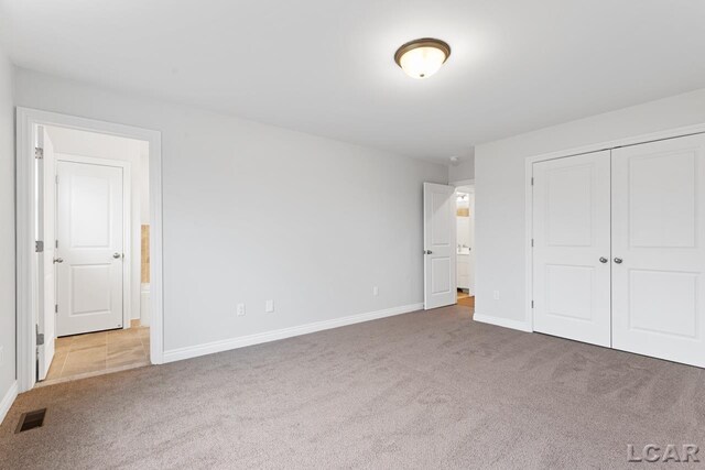 2819 Eunice Cir, Adrian, MI 49221 - unfurnished bedroom with carpet, baseboards, a closet, and ensuite bath