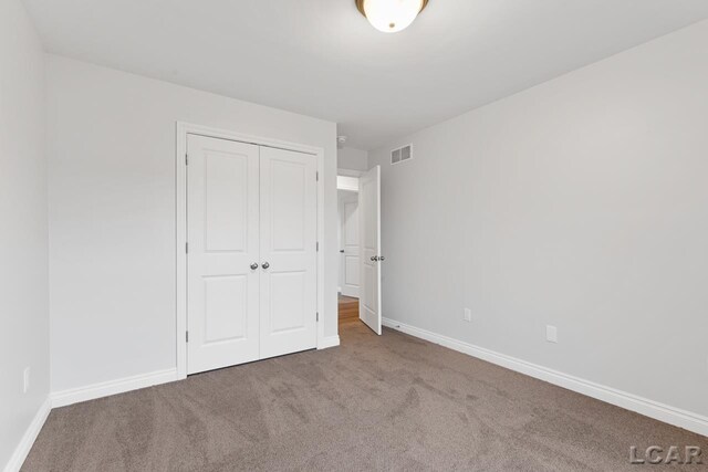 2819 Eunice Cir, Adrian, MI 49221 - unfurnished bedroom featuring carpet floors, a closet, and baseboards