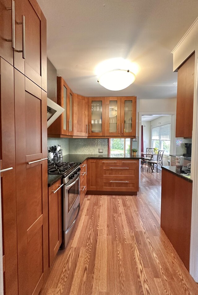 26314 E St, Saint Clair Shores, MI 48081 - kitchen with stainless steel gas stove, brown cabinetry, dark countertops, and light wood-style floors