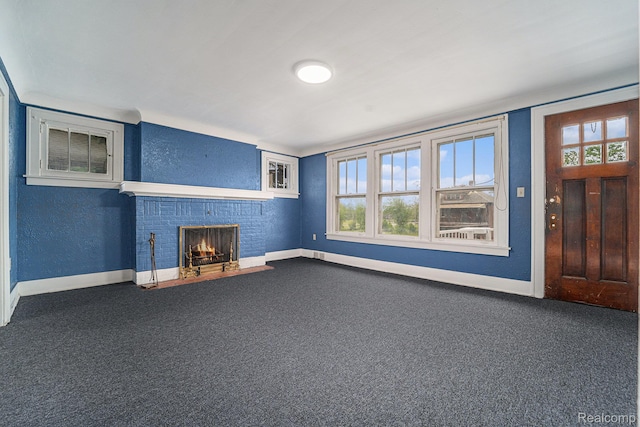 74 W Dakota, Highland Park, MI 48203 - unfurnished living room with baseboards, dark colored carpet, a brick fireplace, and a textured wall