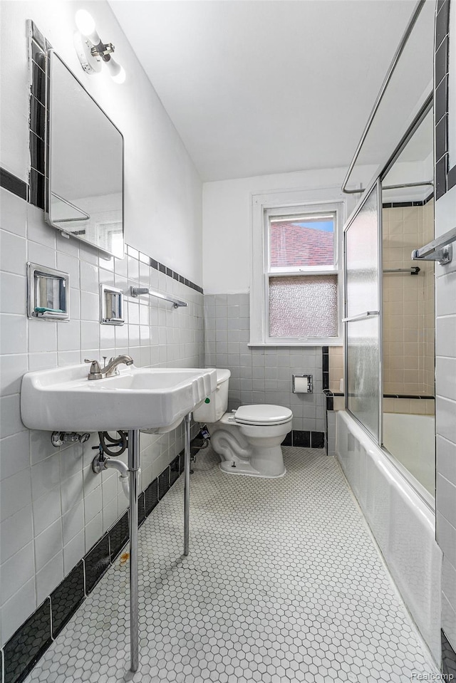74 W Dakota, Highland Park, MI 48203 - full bathroom with toilet, enclosed tub / shower combo, tile walls, wainscoting, and tile patterned flooring