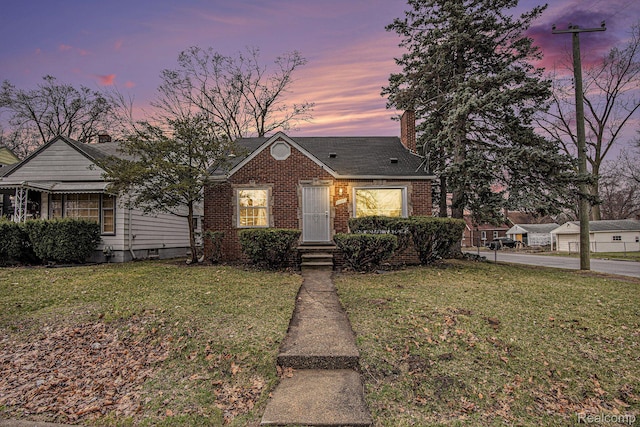 20265 Yonka St, Detroit, MI 48234 - view of front of house featuring brick siding, a front yard, and a chimney