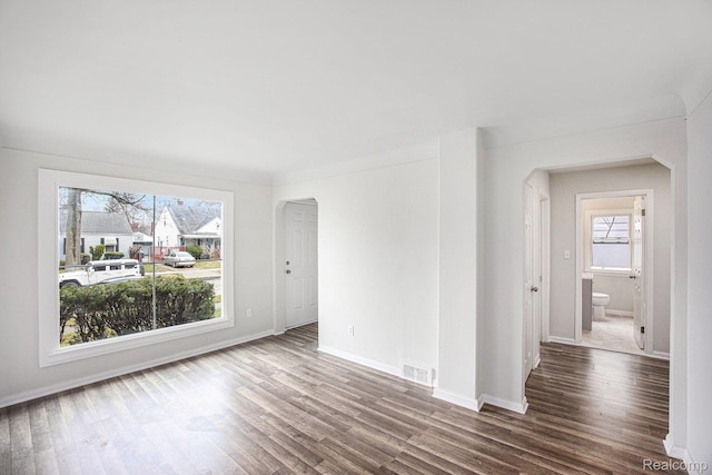 20265 Yonka St, Detroit, MI 48234 - empty room with arched walkways, healthy amount of natural light, wood finished floors, and baseboards