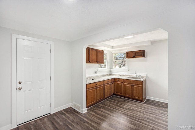 20265 Yonka St, Detroit, MI 48234 - kitchen featuring dark wood-type flooring, baseboards, light countertops, and brown cabinets