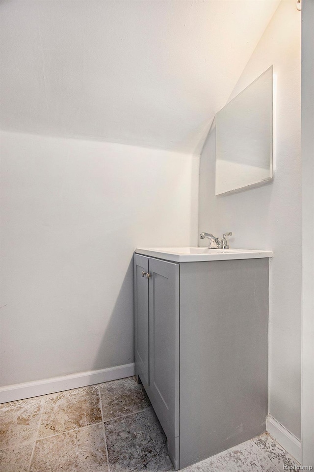 20265 Yonka St, Detroit, MI 48234 - bathroom featuring lofted ceiling, baseboards, and vanity