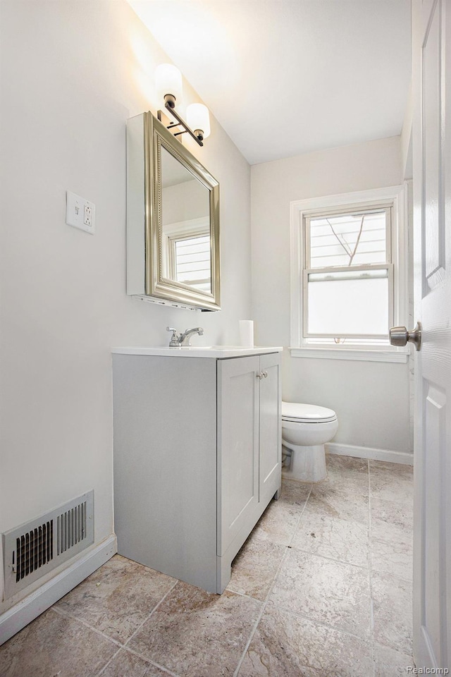 20265 Yonka St, Detroit, MI 48234 - bathroom with toilet, vanity, plenty of natural light, and baseboards
