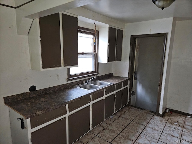9086 Plainview Ave, Detroit, MI 48228 - kitchen with dark countertops, a sink, and light tile patterned flooring