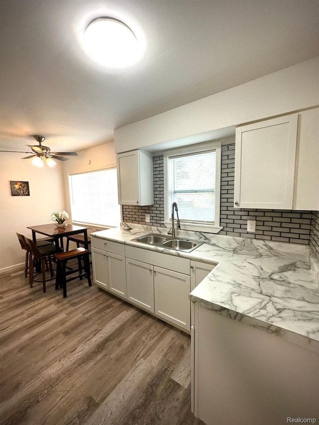 2825 Raskob St, Flint, MI 48504 - kitchen with a sink, dark wood finished floors, backsplash, a ceiling fan, and white cabinets
