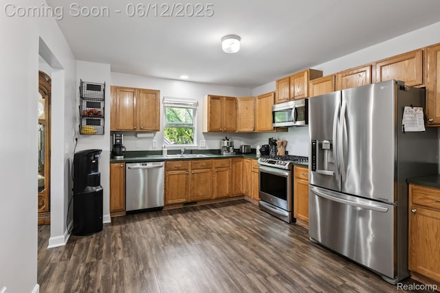 6287 Woodring Ct, Brighton, MI 48116 - kitchen featuring stainless steel appliances, dark countertops, dark wood-style floors, a sink, and recessed lighting