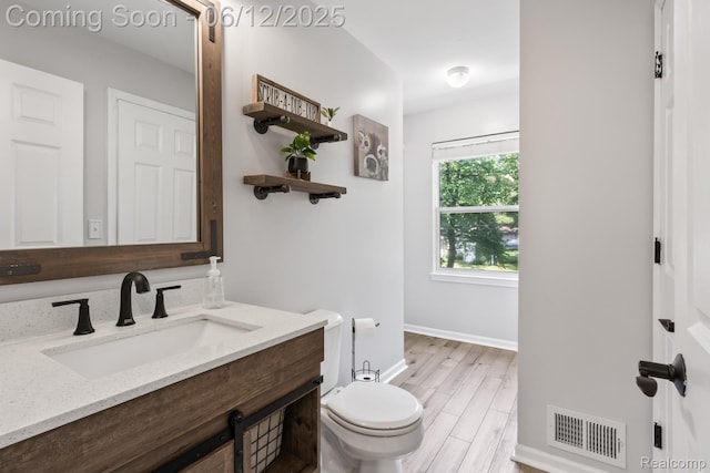 6287 Woodring Ct, Brighton, MI 48116 - bathroom featuring toilet, vanity, wood finished floors, and baseboards