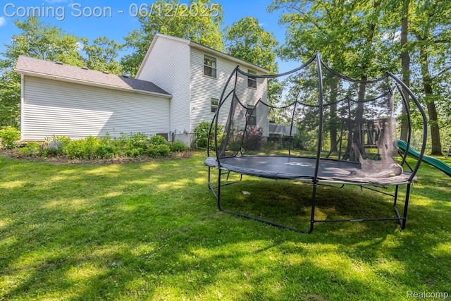 6287 Woodring Ct, Brighton, MI 48116 - back of house featuring a trampoline, a lawn, and a playground