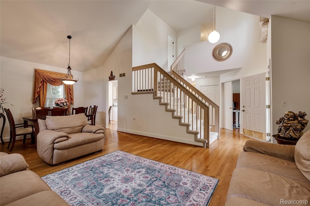 39719 Squire Rd, Novi, MI 48375 - living area featuring high vaulted ceiling, stairs, wood finished floors, and baseboards