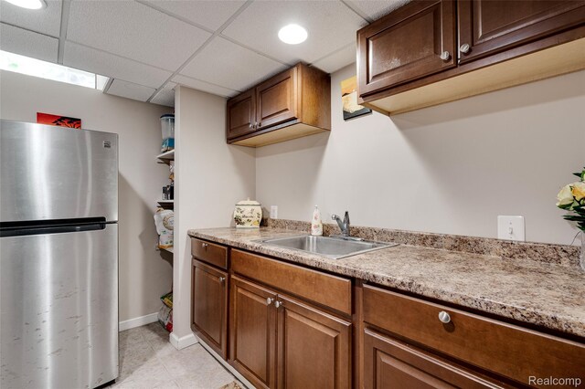 39719 Squire Rd, Novi, MI 48375 - kitchen with freestanding refrigerator, a sink, light countertops, brown cabinetry, and light tile patterned flooring