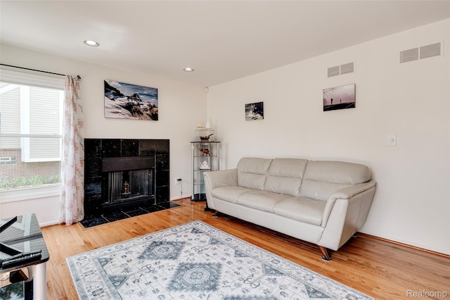 39719 Squire Rd, Novi, MI 48375 - living room with wood finished floors, a tiled fireplace, recessed lighting, and baseboards