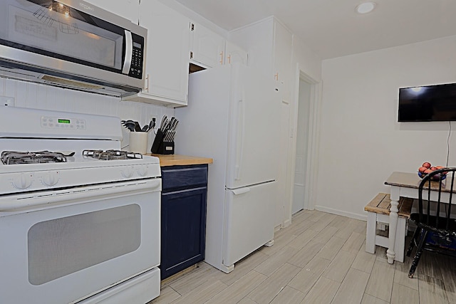 600 Center Dr, Tecumseh, MI 49286 - kitchen featuring white appliances, light wood-style floors, blue cabinetry, butcher block counters, and white cabinets