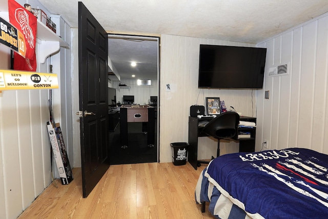 600 Center Dr, Tecumseh, MI 49286 - bedroom with wood finished floors, a desk, and a textured ceiling