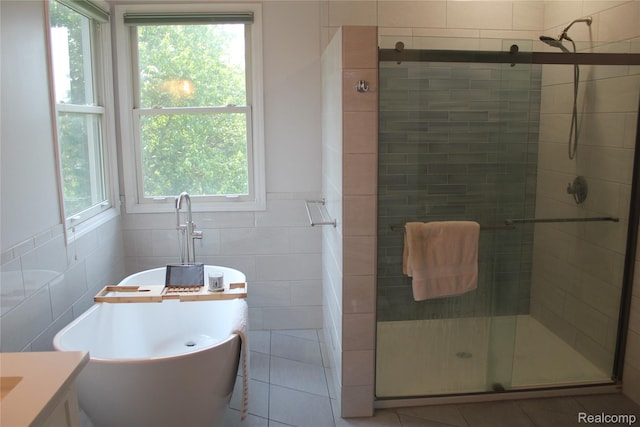 300 Crestway Ct, Saline, MI 48176 - bathroom featuring tile walls, a stall shower, vanity, tile patterned flooring, and a freestanding tub