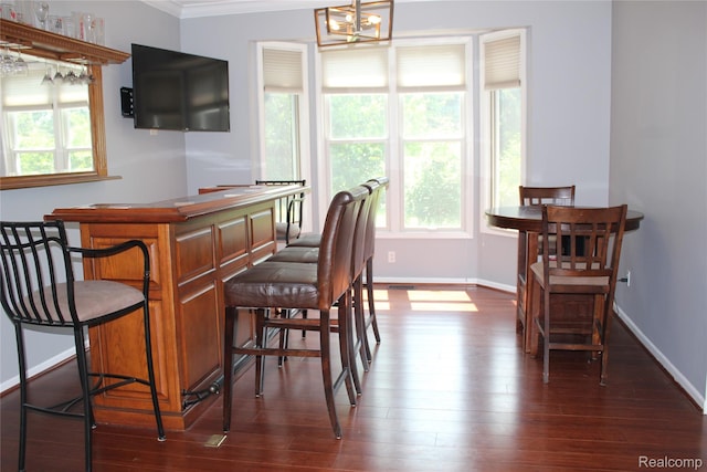 300 Crestway Ct, Saline, MI 48176 - dining space featuring crown molding, dark wood-style flooring, a chandelier, and a dry bar